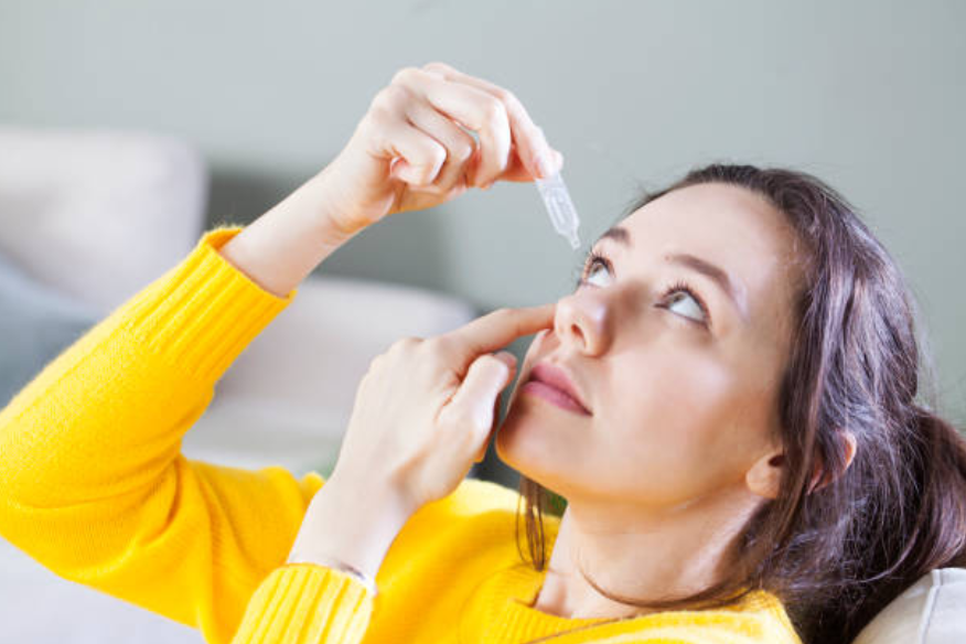 Eye drops treatment for conjunctivitis eye infection redness relief Close up image of woman using eye drops for treatment of dry eye eye infection allergy and irritation Eye drops help relieve redness watering burning and discomfort
