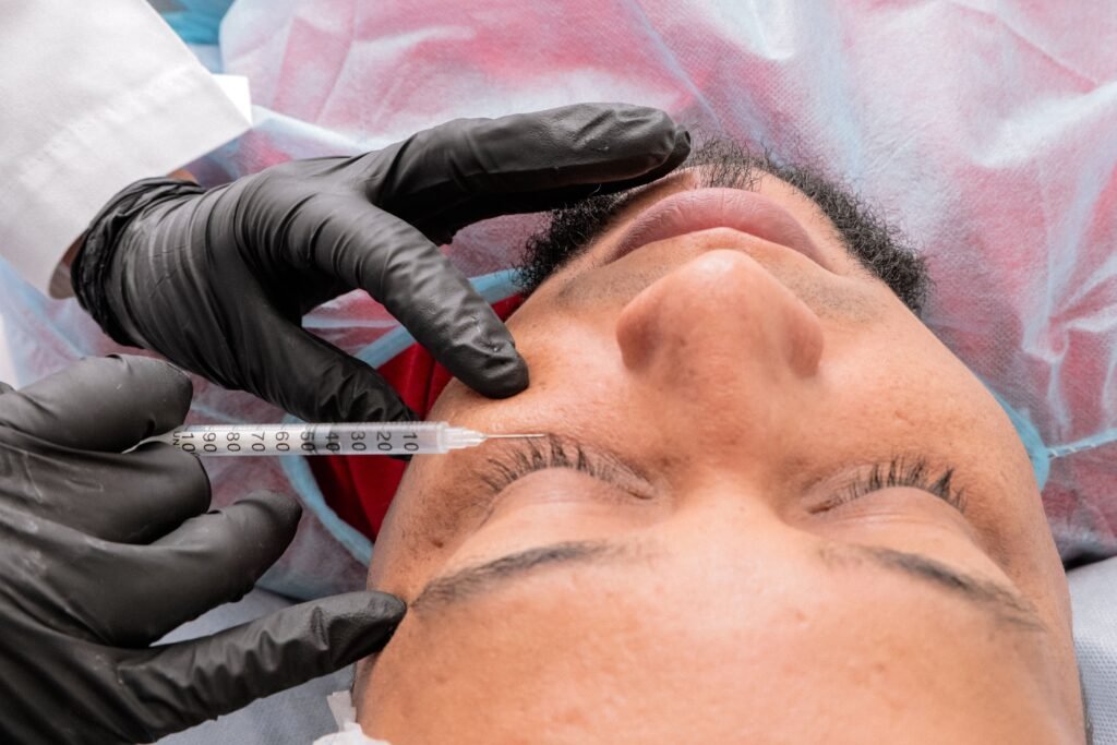 Man receiving facial treatment with syringe in medical facility