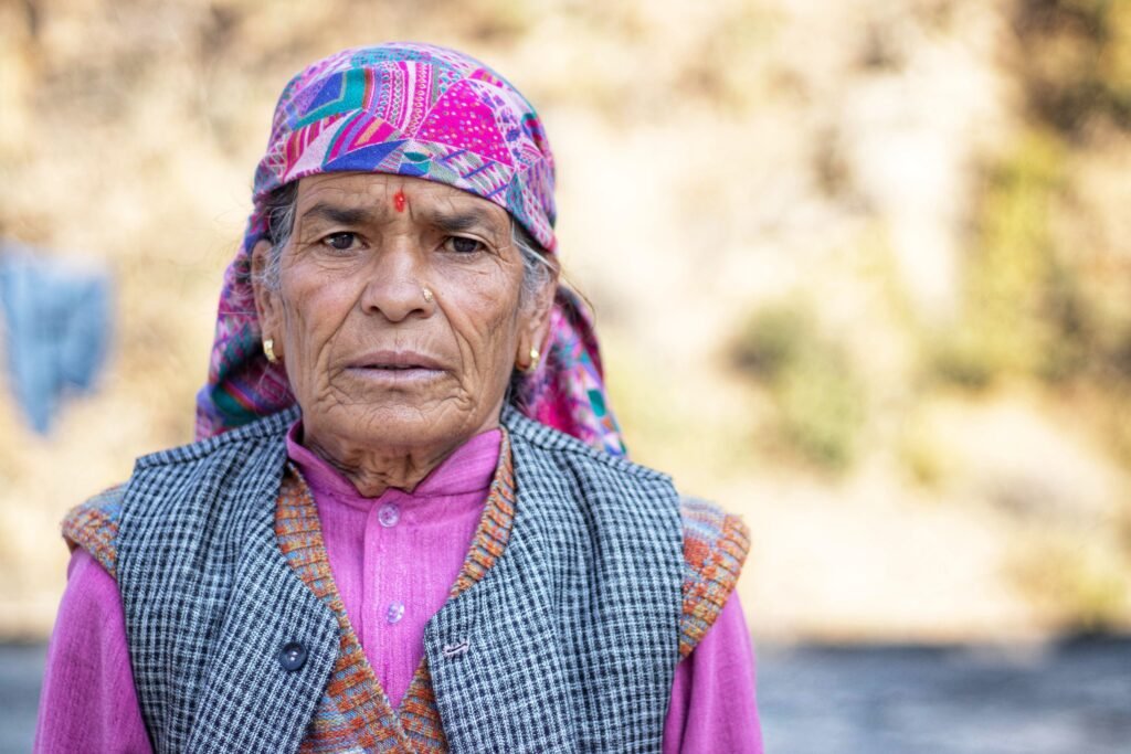 Close up portrait of an elderly woman wearing a colorful headscarf outdoors