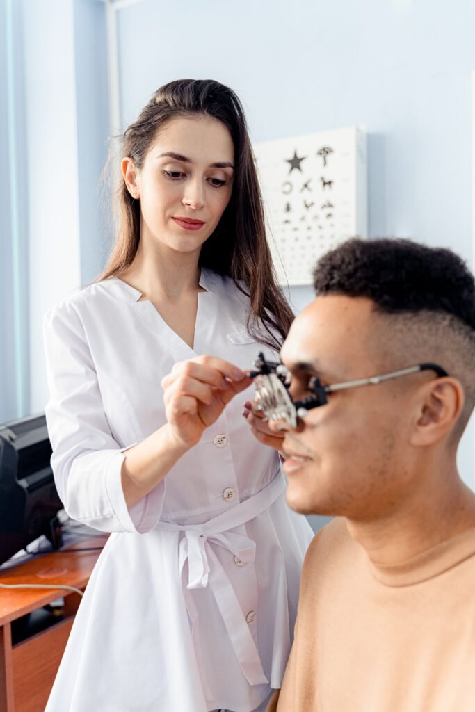 pexelsphoto67497356749735 Crystal Clear Eye Clinic Best Eye Clinic in Andheri Mumbai A female optometrist adjusts an optical trial lens frame during an eye examination of a male patient